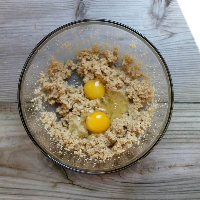 Eggs on top of cookie dough in a glass bowl.