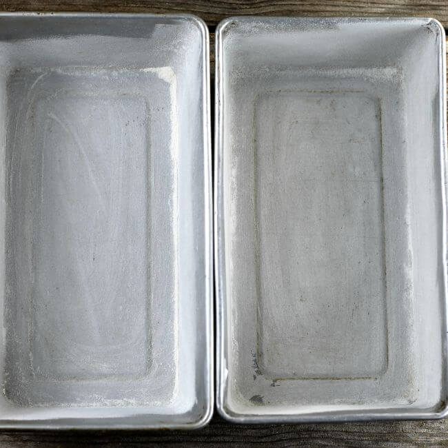 Two loaf pans that have been greased and floured.