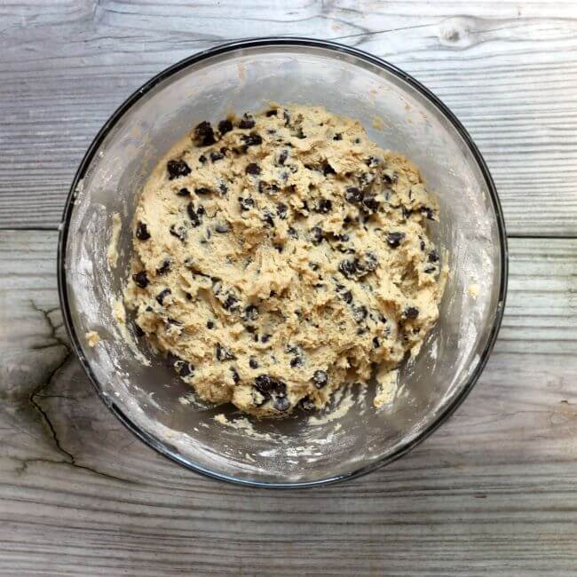 Chocolate chip cookie dough in a glass bowl.