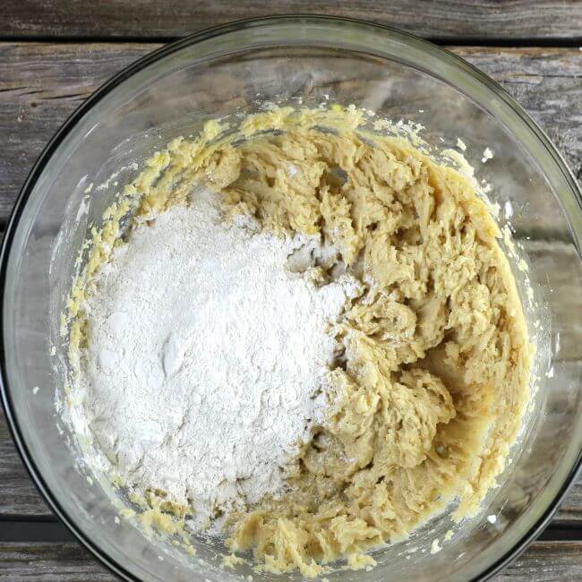 Adding flour to the cookie dough.