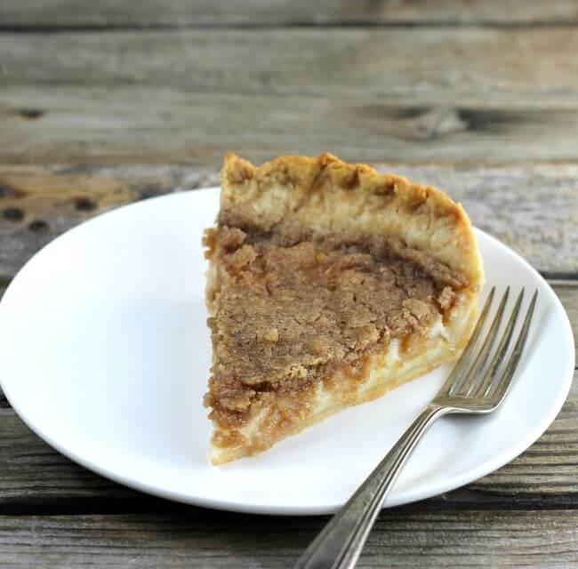 Side angle view of a slice of pie on a white plate.