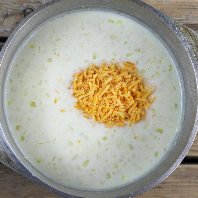 Shredded cheese is added to the soup.