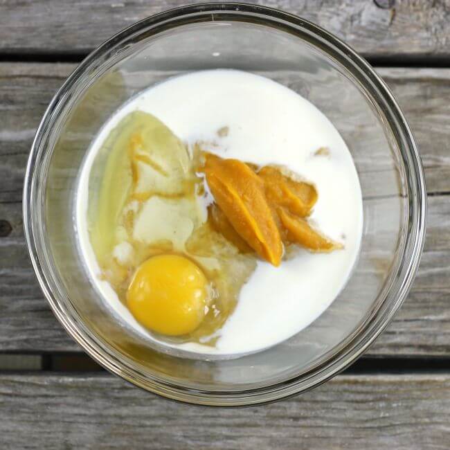 Pumpkin puree, egg, and cream in a glass bowl.
