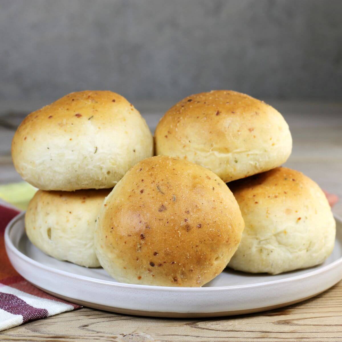 A side view of a plate of buns on a cream color plate.