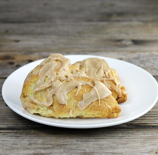 Two apple scones on a white plate.