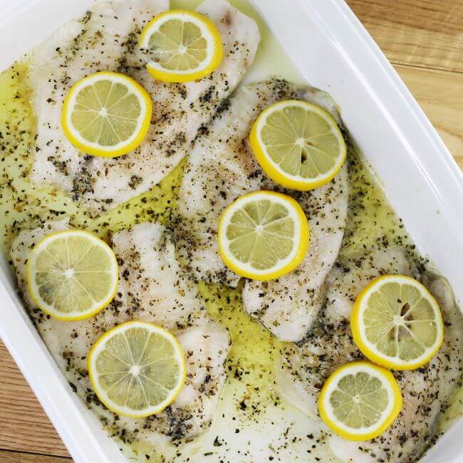 Baked fish in a white baking dish.