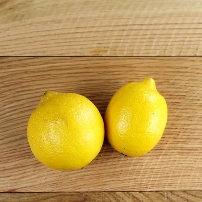 Looking down at two lemons on a table.