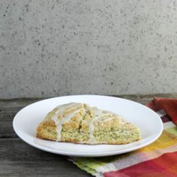 Lemon poppy seed scone on white plate with plaid napkin.