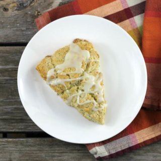 Lemon poppy seed scone on a white plate with a plaid napkin.