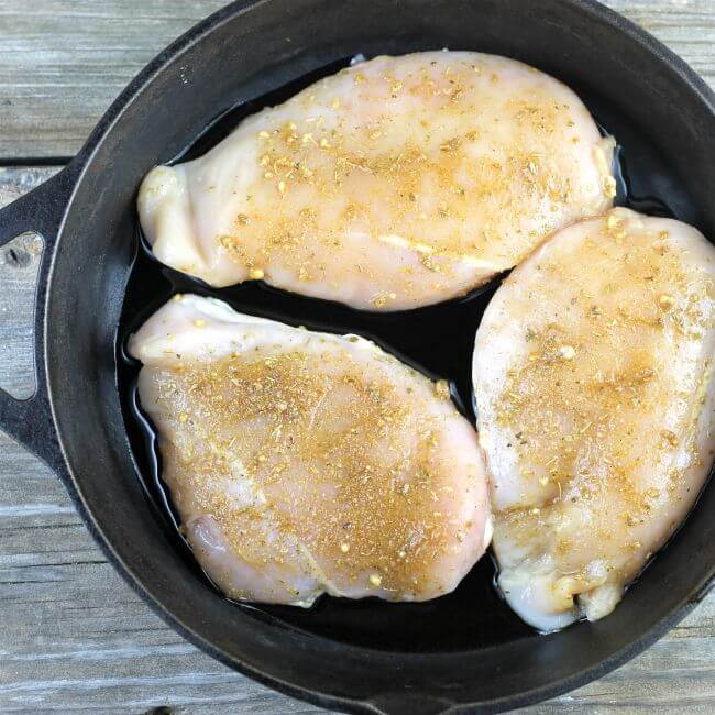Chicken breast in a cast-iron skillet.