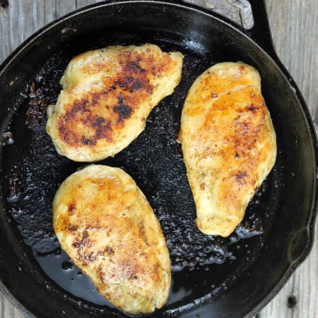 Cooked chicken in a cast-iron skillet.