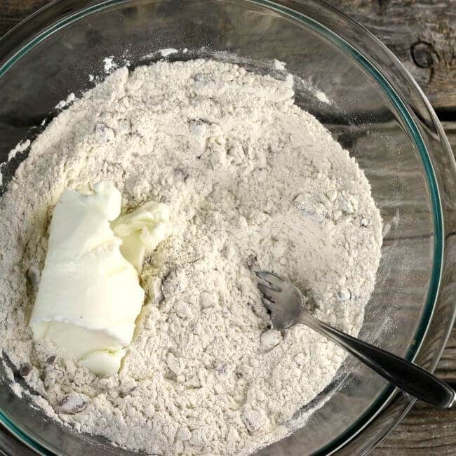 Adding shortening to the flour mixture.