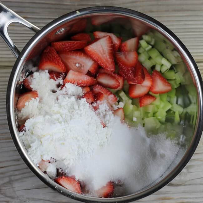 Strawberries, rhubarb, sugar, and cornstarch in a saucepan.