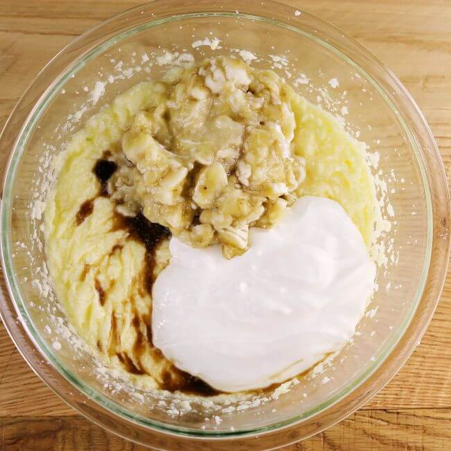 Bananas, sour cream, and vanilla are added to the mixing bowl.