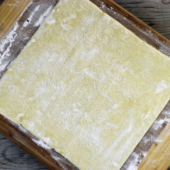 Butter and sugar are brushed over top of the dough.