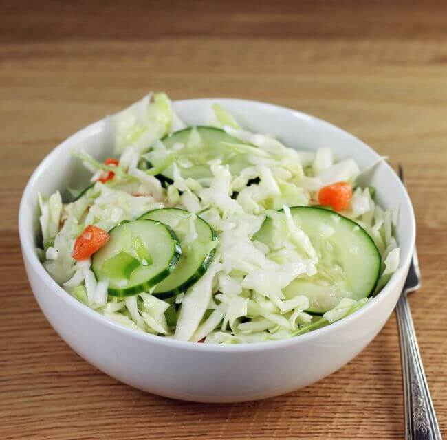 Side angle view of a bowl of cabbage salad.