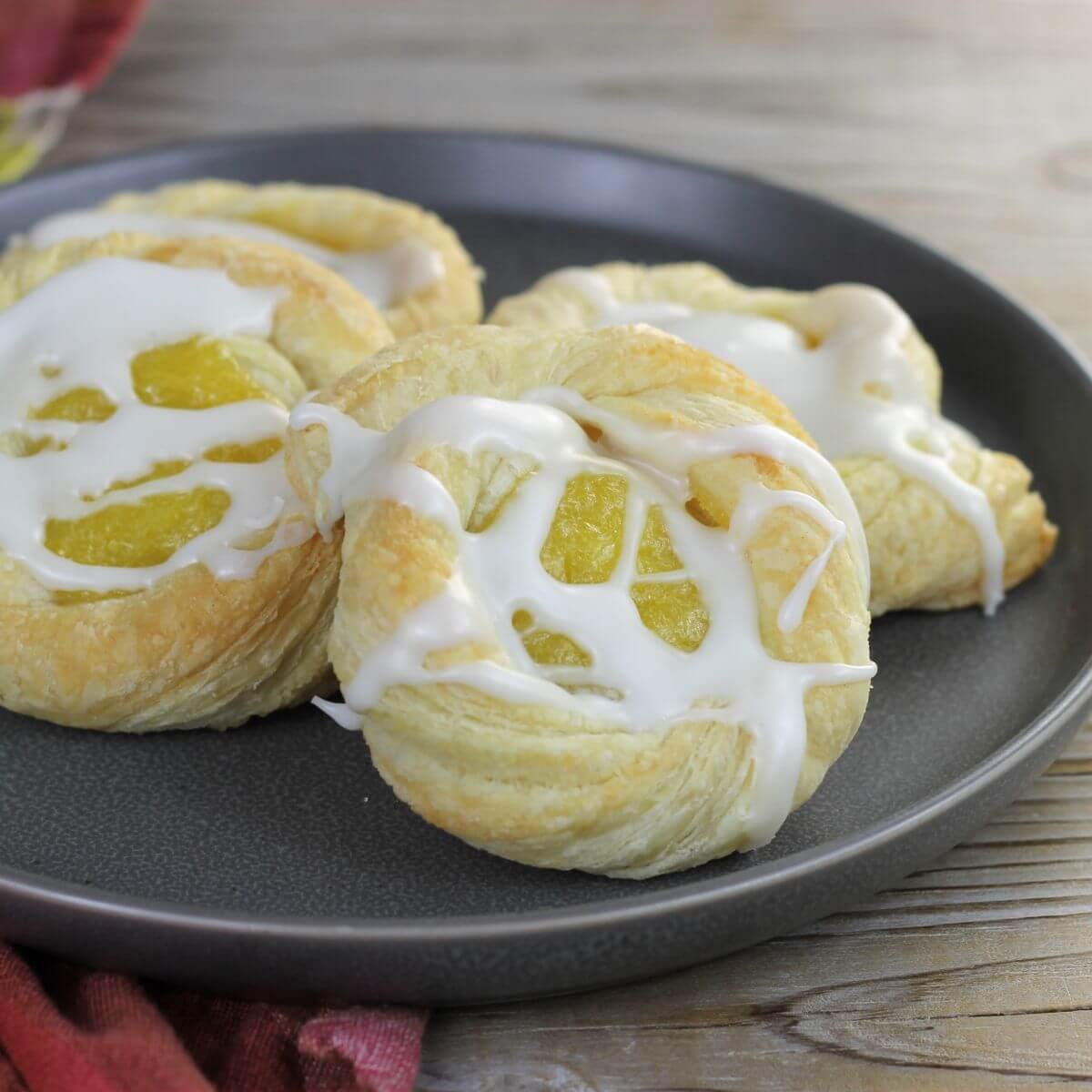 Looking at a side angle view of a plate with lemon Danish on it.