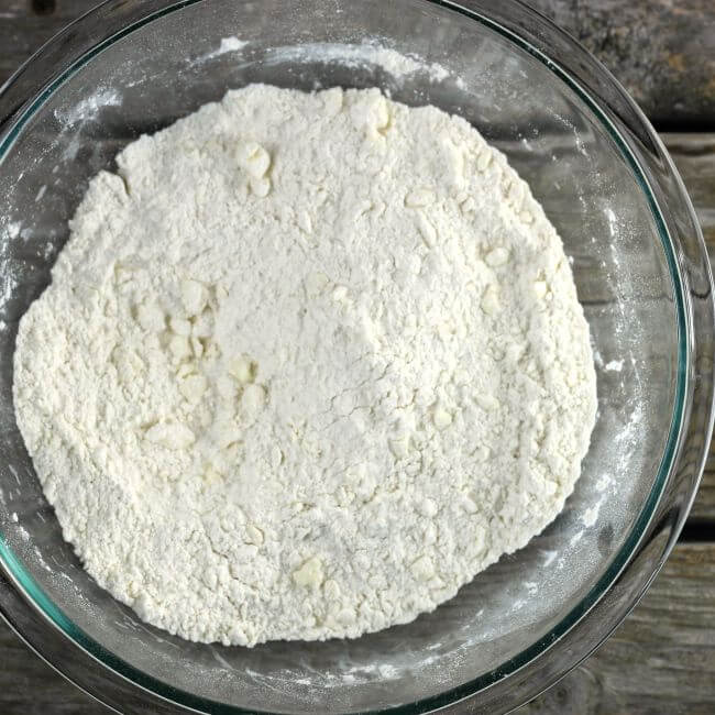 The butter is cut into the flour mixture to small pea size