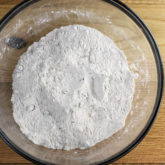 Flour and other dry ingredients in a glass mixing bowl.