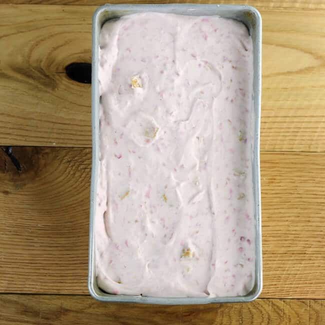 Frozen raspberry cheese cake ice cream in a loaf pan.