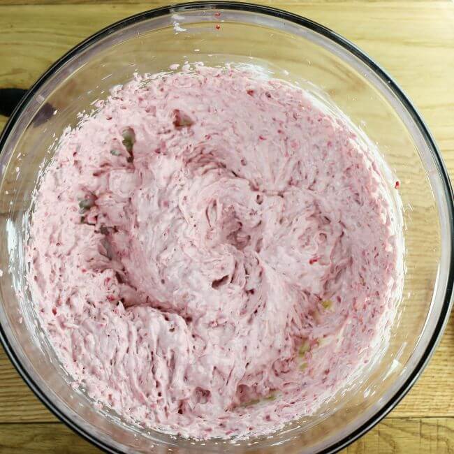 Whipped cream cheese and raspberries in a bowl.