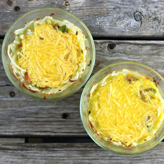 Eggs and cheese added to the custard cups.