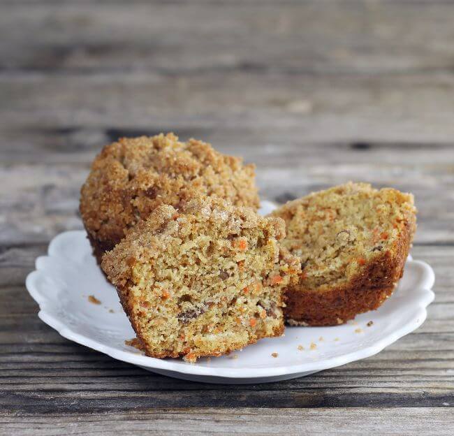 Muffins on a plate with one of the muffins cut in half.