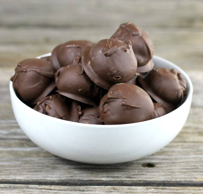 Peanut butter balls in a white bowl.