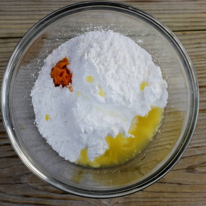 Powdered sugar, orange zest and juice are added to a medium bowl.
