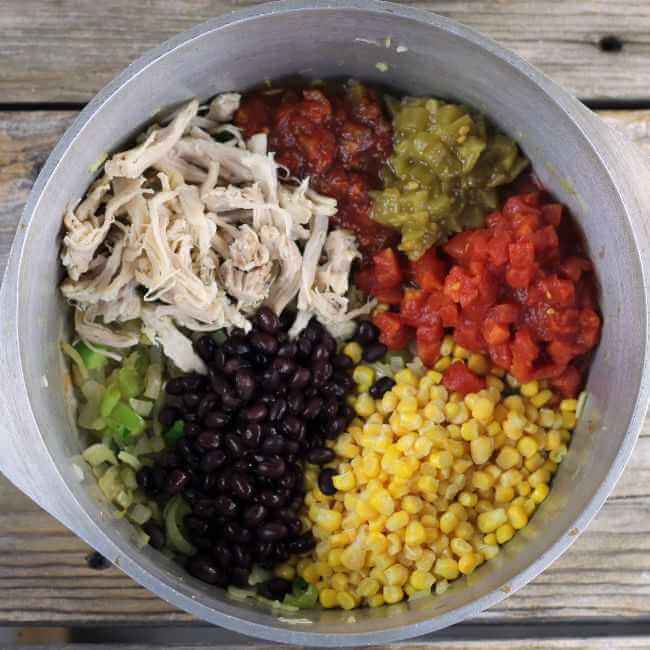 Chicken, corn, tomatoes, black beans, chiles, and salsa in a Dutch oven.