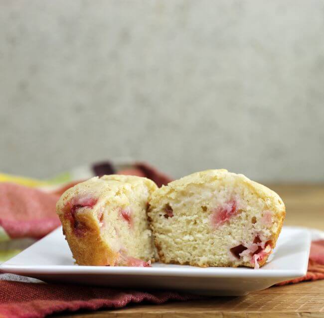 A muffin cut in half on a white plate.