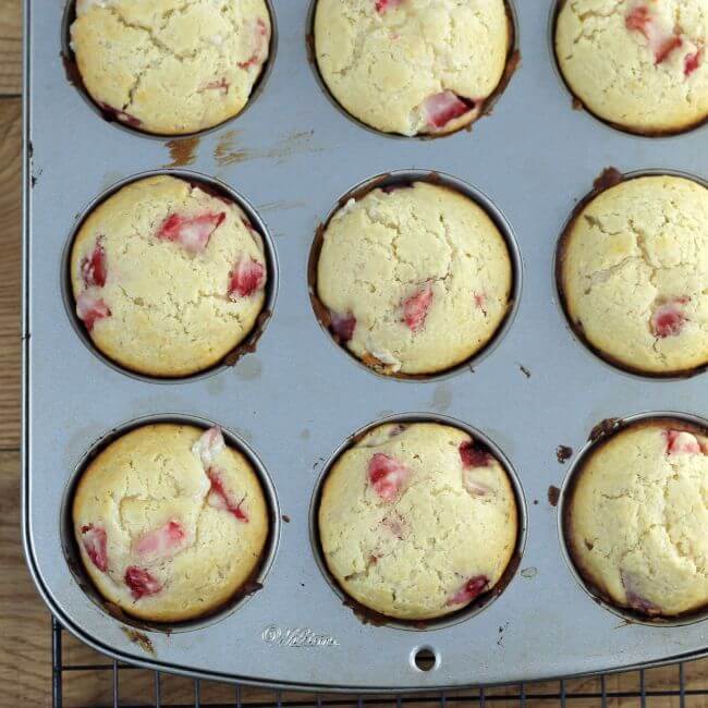 Baked strawberry muffins in muffin tins.