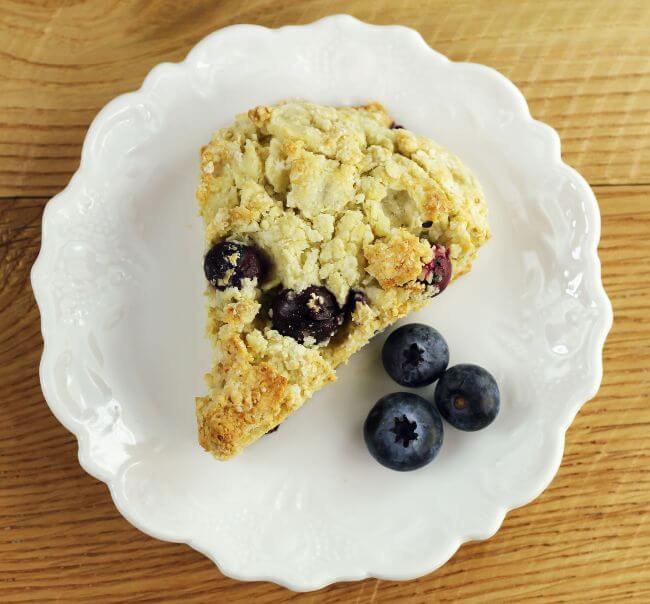 Looking down at a plate with a scone and berries.
