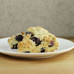 Side angle view of two scones on a white plate.