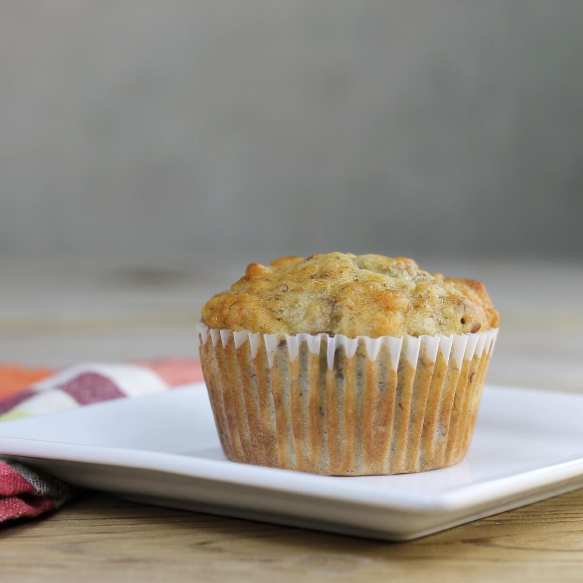 A side view of a muffin on a white plate.