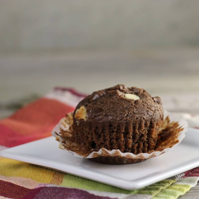 Looking at a side view of a chocolate muffin with the paper pulled down.