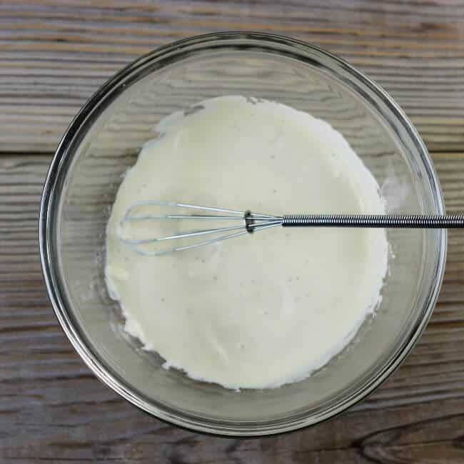 Garlic aioli in a bowl with a whisk.