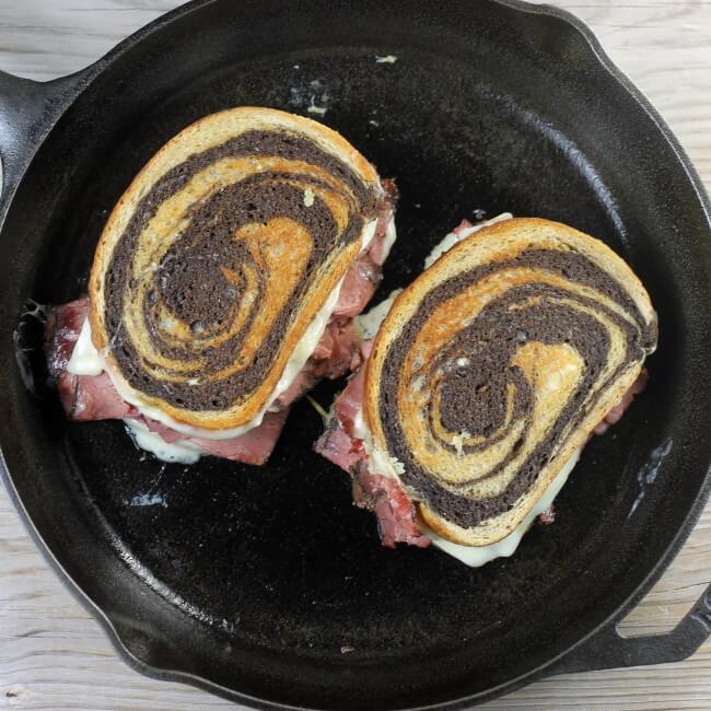 Looking down at two grilled sandwiches in a skillet.