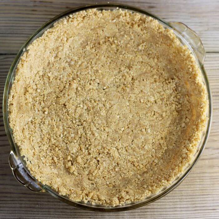 Overlooking a graham cracker crust in a pie plate. 
