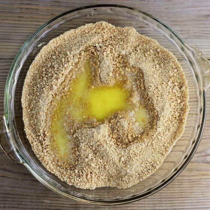 Add melted butter to the graham cracker and sugar combination. 