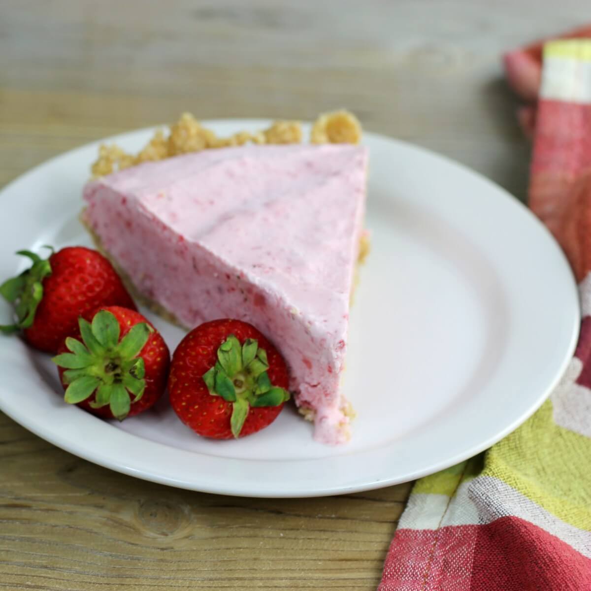 A slice of frozen strawberry pie on a white plate.