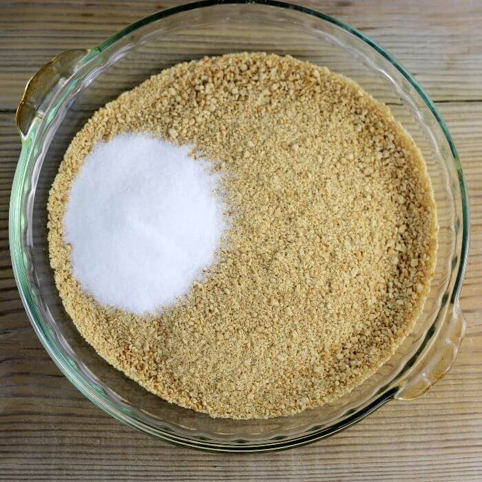 Combine graham cracker crumbs and sugar in a pie plate.