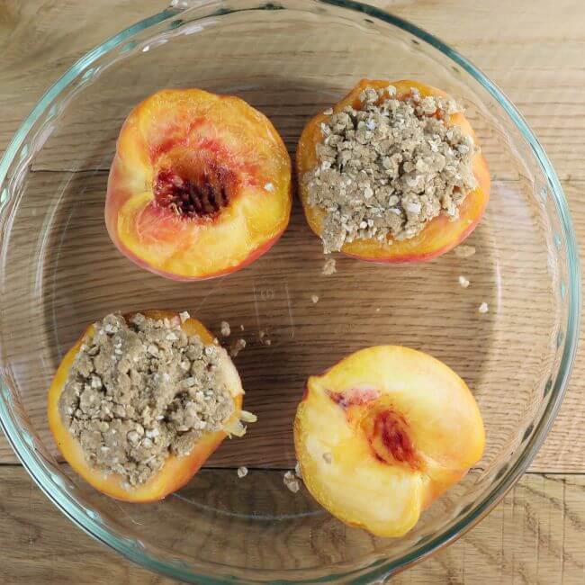 The crumble is put on top of the peaches in the glass baking dish.