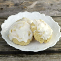 Frosted lemon cookies on a white plate.