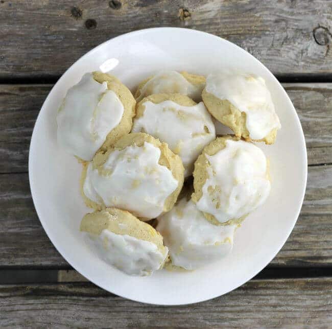 Frosted cookies piled on a white plate.