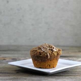 Side view of a muffin on a white square plate.