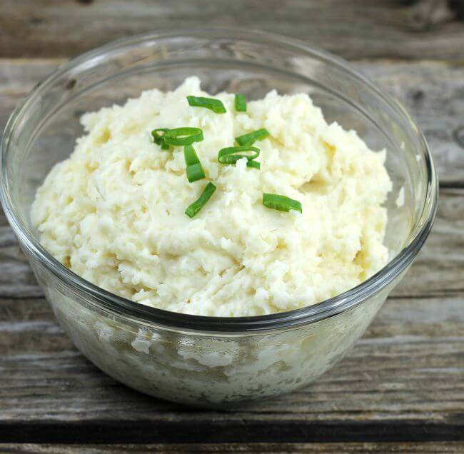 Side angle view of mashed potatoes in a glass bowl.