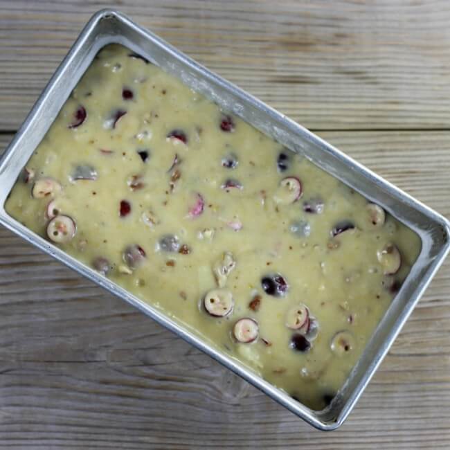 The quick bread batter is spread into the prepared loaf pan.