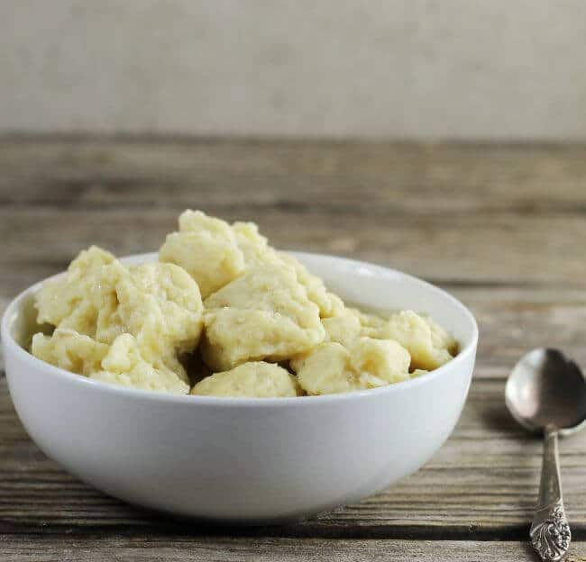 Side view a white bowl with egg dumplings. 