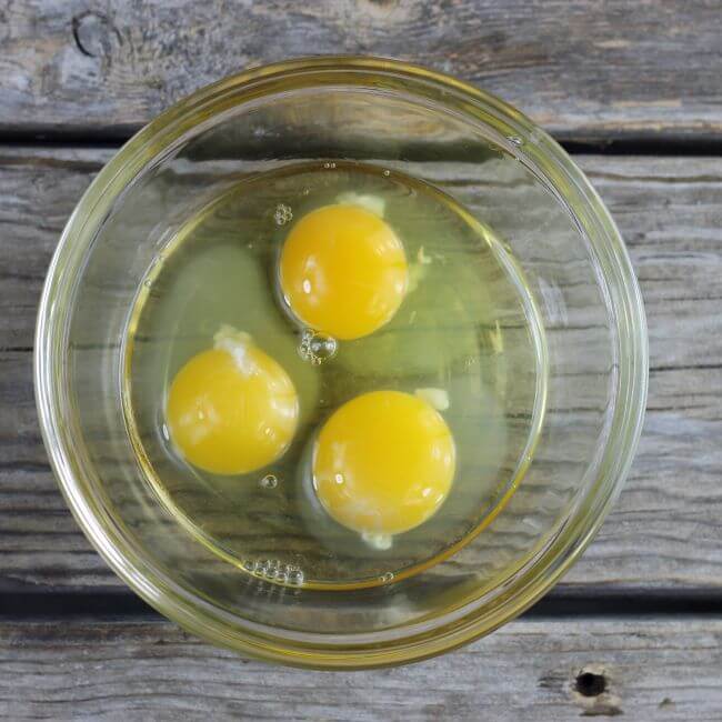 Three eggs in a glass bowl.